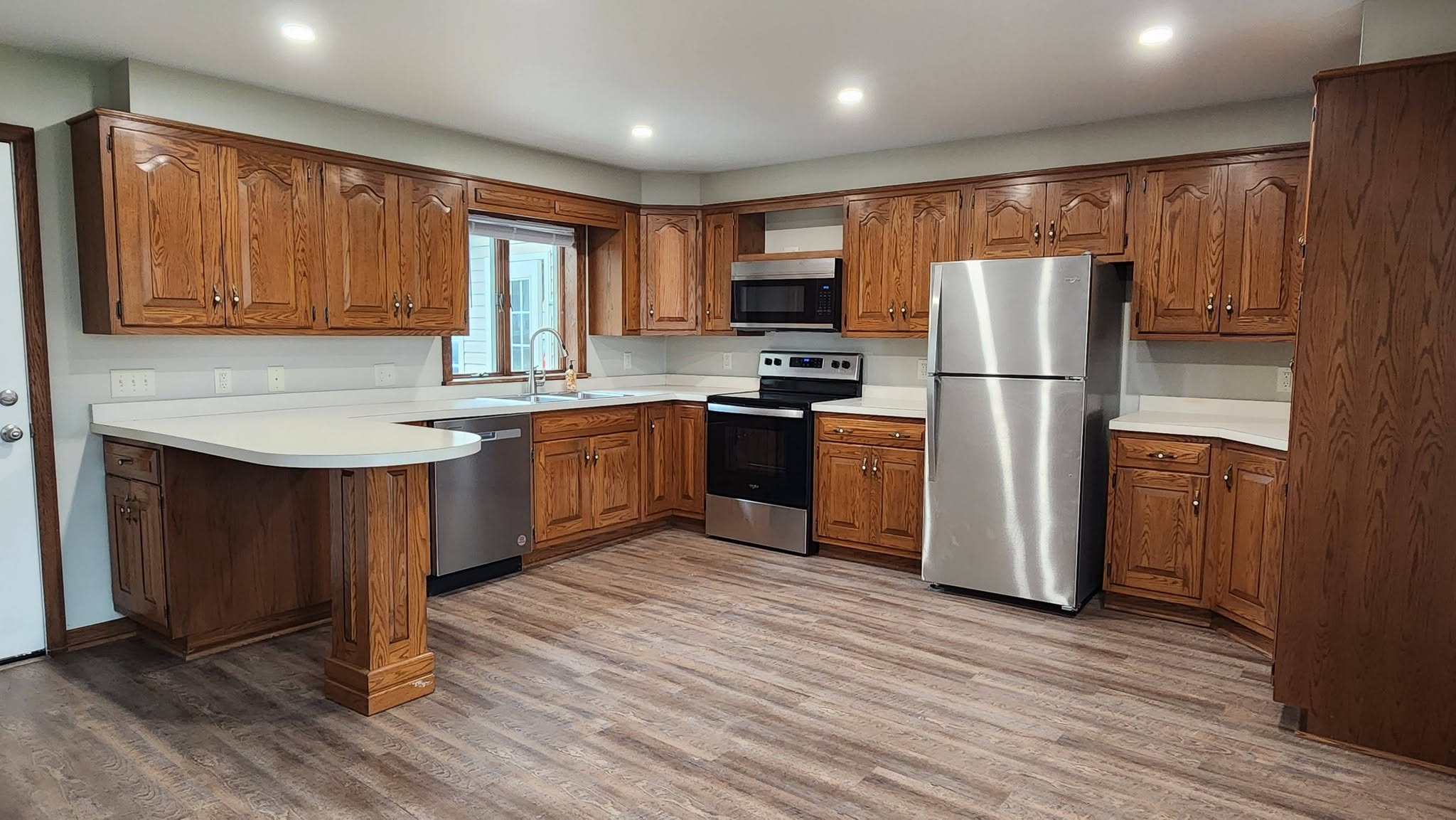 The renovated kitchen with oak cabinets and stainless appliances