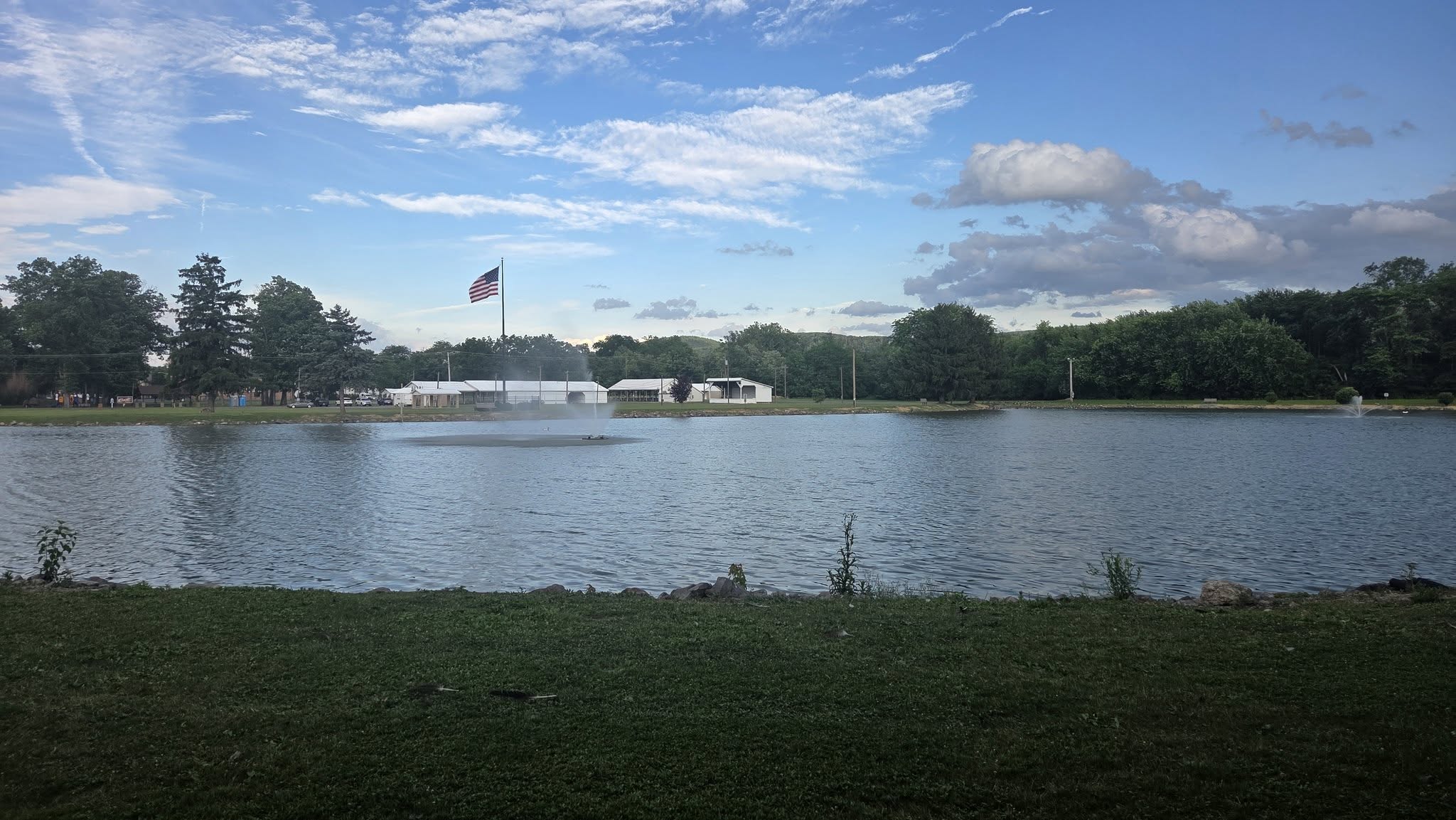 Calm water and a green treeline near the house